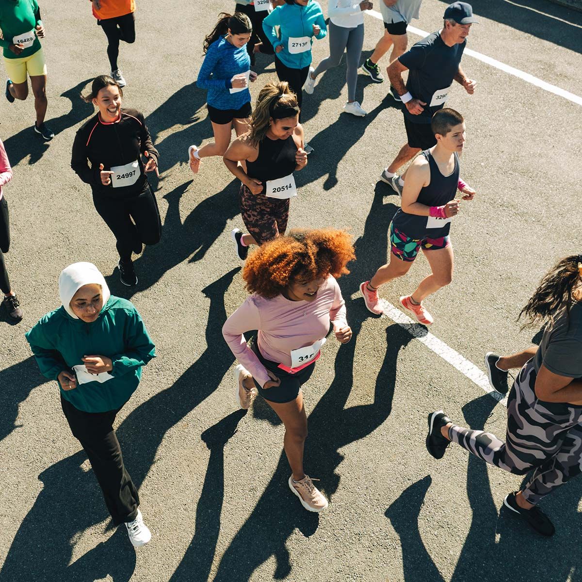 Biegacze uczestniczą w maratonie na miejskiej ulicy. - tytułowa