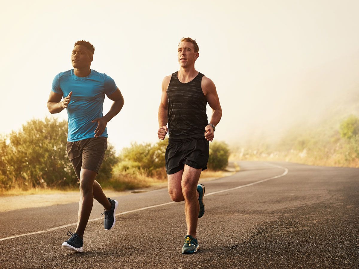  Dwóch biegaczy, biegają po drodze w otoczeniu natury. - zdjęcie
