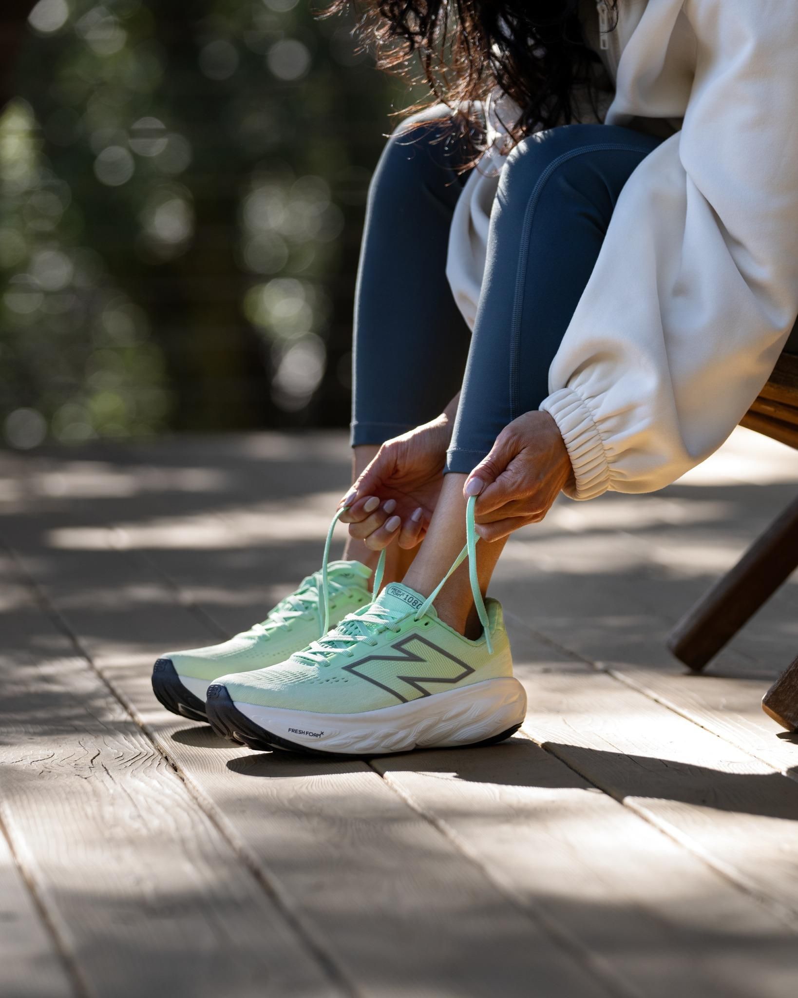 egy nő egy padon köti a cipőjét