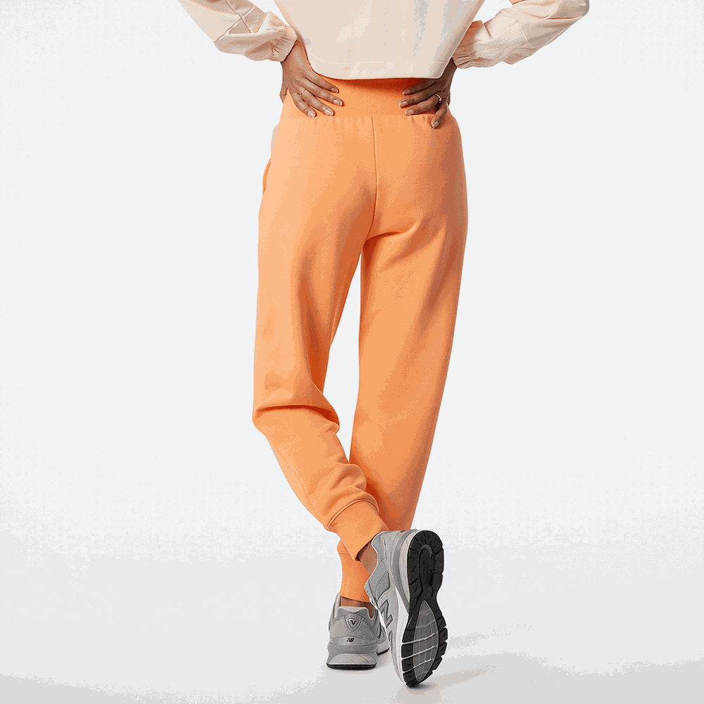 Spodnie New Balance WP21503PGZ – pomarańczowe